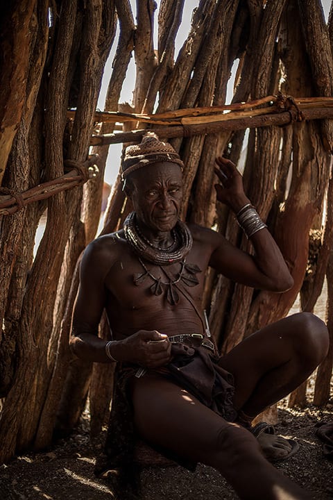 The village chief sits inside a hut talking with members of his tribe on August 12, 2015 in the Kunene Region of Namibia. Like most other tribal societies, the Himba people are very distinct with regards to the roles of the men and women. Typically, the men are the warriors; they are the ones who bring food to the table, and the ones who are the authority on tribal affairs. The Himba are indigenous peoples. One of Southern Africa's last traditionally living pastoral tribes with an estimated population of about 50,000 people living in northern Namibia, they are semi-nomadic with the men tending to livestock. The Himba live by herding sheep, goats and some cattle, and they move location several times a year to graze their livestock. The Himba are a people that live very distant from the "modern-western" world. Although they have contact with the western society, the Himba people have managed to maintain their traditional lifestyle.