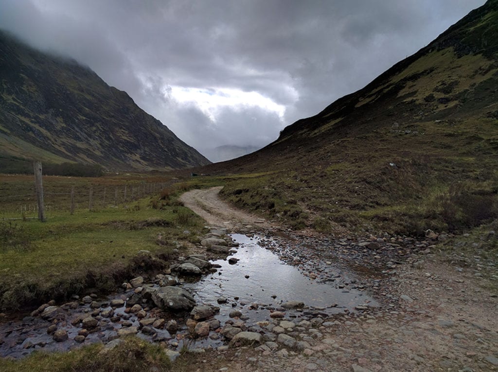 Day One. The entry into Glen Licht, Highlands of Scotland. Other than the mountains, canyons, lakes and general all-around beauty, there’s not much to see in Shiel Bridge. Two miles out, I turned east to enter Glen Licht for the business end of this hike. Stonehaven awaited me two hundred miles through this gap, give or take 600-700 turns. The next town, Fort Augustus, was a three-day walk from this point. On my back, I carried a Deuter 65L+10 pack with a stout Scottish broomstick and a half bottle of water (more on accessories later). Total approximate weight was thirty-five pounds.Other than the mountains, canyons, lakes and general all-around beauty, there’s not much to see in Shiel Bridge. Two miles out, I turned east to enter Glen Licht for the business end of this hike. Stonehaven awaited me two hundred miles through this gap, give or take 600-700 turns. The next town, Fort Augustus, was a three-day walk from this point. On my back, I carried a Deuter 65L+10 pack with a stout Scottish broomstick and a half bottle of water (more on accessories later). Total approximate weight was thirty-five pounds.